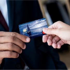 close up of businessman handing businesswoman credit card
